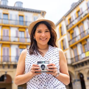 Tourist woman enjoying visiting the city taking photos of the trip, enjoying summer vacation